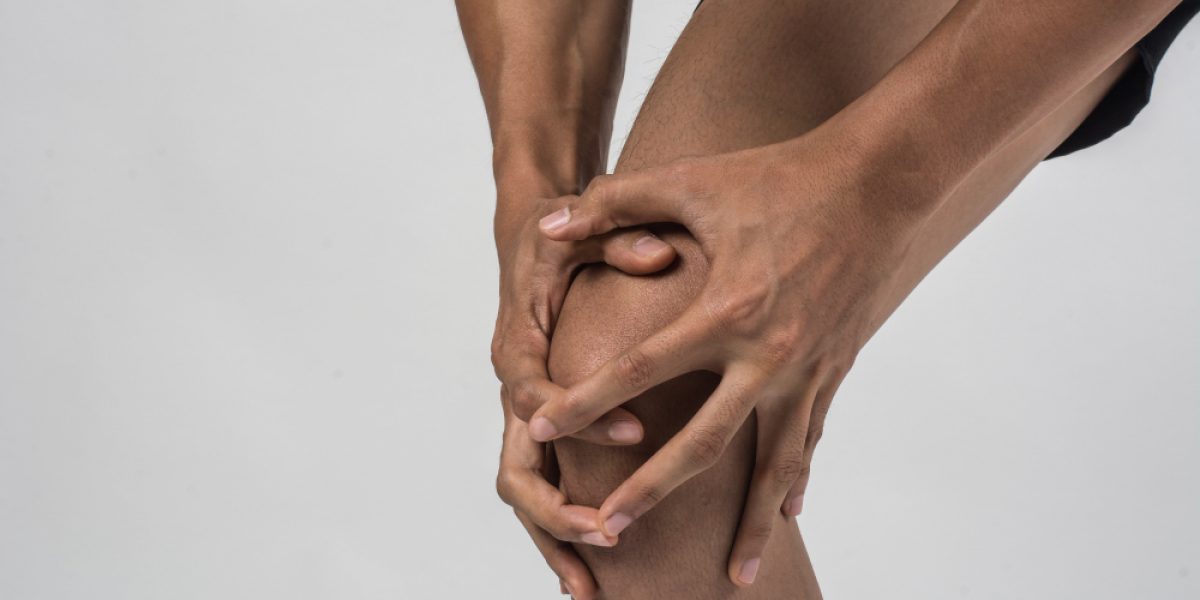 young-sport-man-with-strong-athletic-legs-holding-knee-with-his-hands-pain-after-suffering-ligament-injury-isolated-white